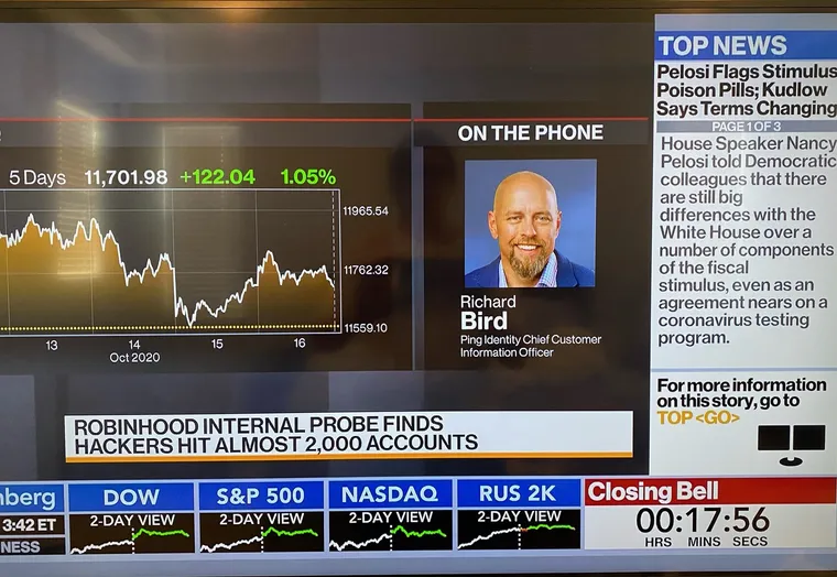 A television showing Bloomberg Markets: The Close — a headshot of Richard Bird labeled On The Phone and Ping Identity Chief Customer Information Officer, above a chyron reading Robinhood internal probe finds hackers hit almost 2,000 accounts